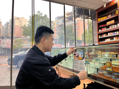 弋陽縣煙草局工作人員在校園周邊零售店張貼未成年人保護宣傳海報